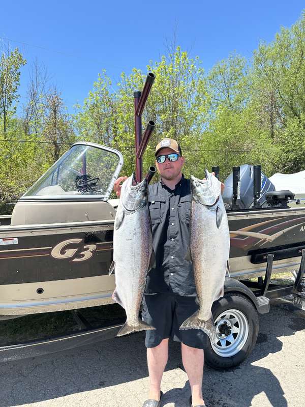 Captain holding two salmon beside the Niagara Chrome boat
