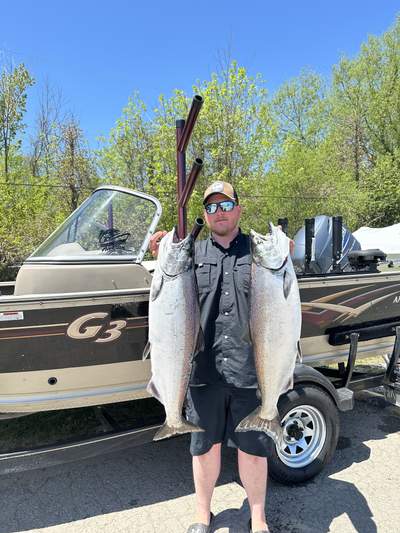 Captain Jesse Swayze with two salmon beside the Niagara Chrome boat
