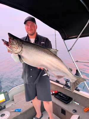 Angler holding a Chinook salmon caught trolling Lake Ontario
